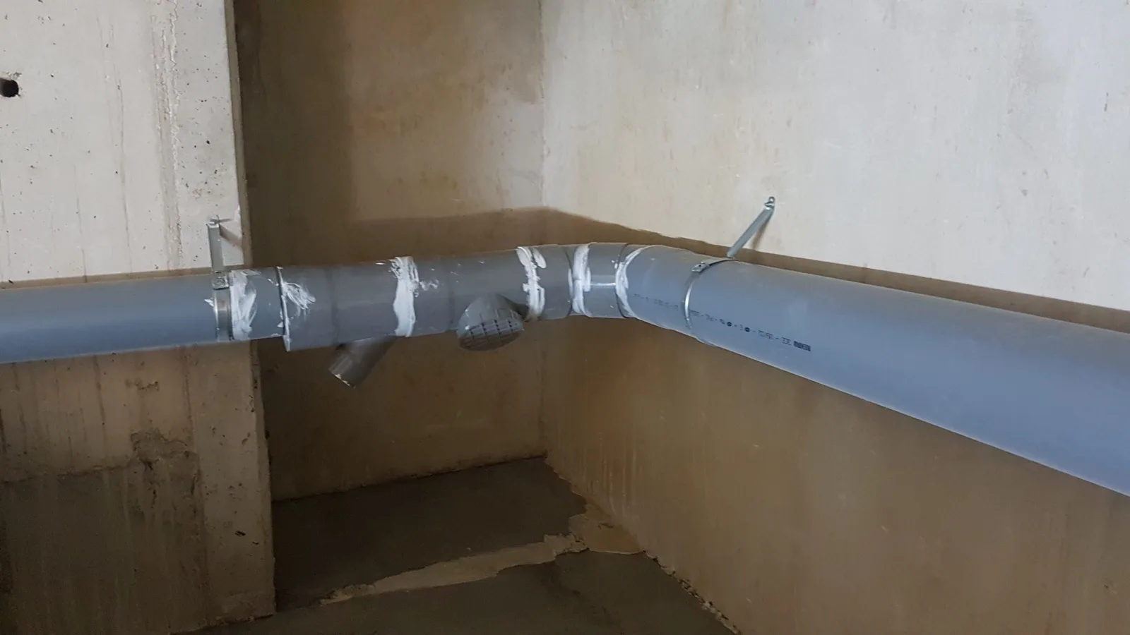 Collecteur PVC horizontal contre mur supporté par colliers TOPCELT
